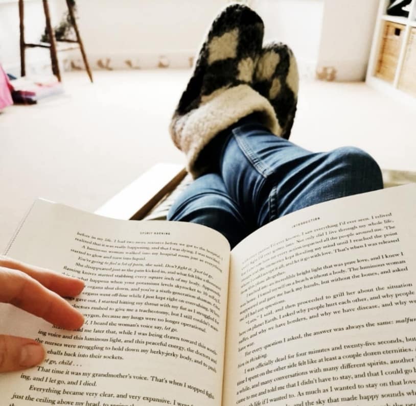 Reading in cosy slippers with a book — new year's resolutions are rubbish rest is best